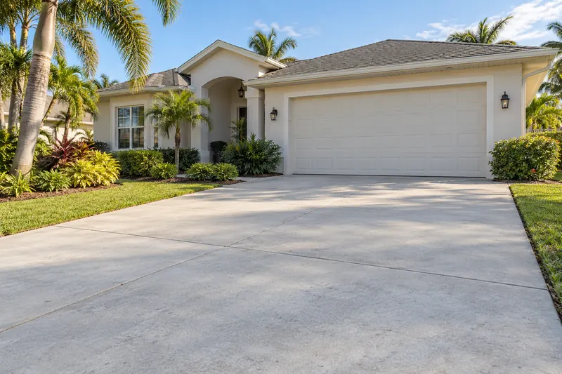 Concrete driveway and walkway in front of a single-story home